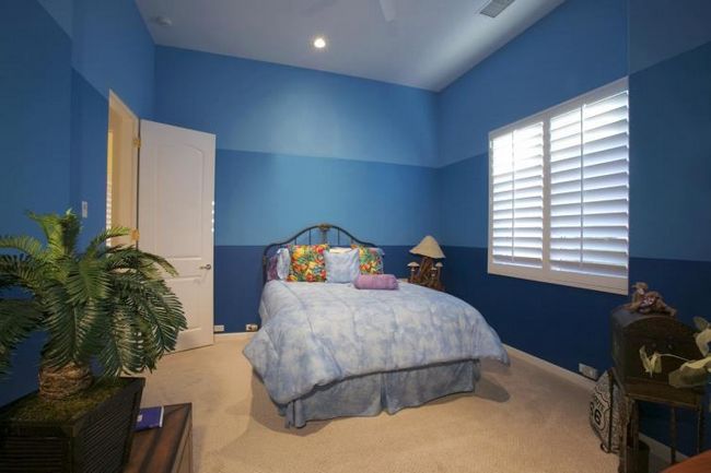 Интерьер спальни со стенами, окрашенными в синий цвет